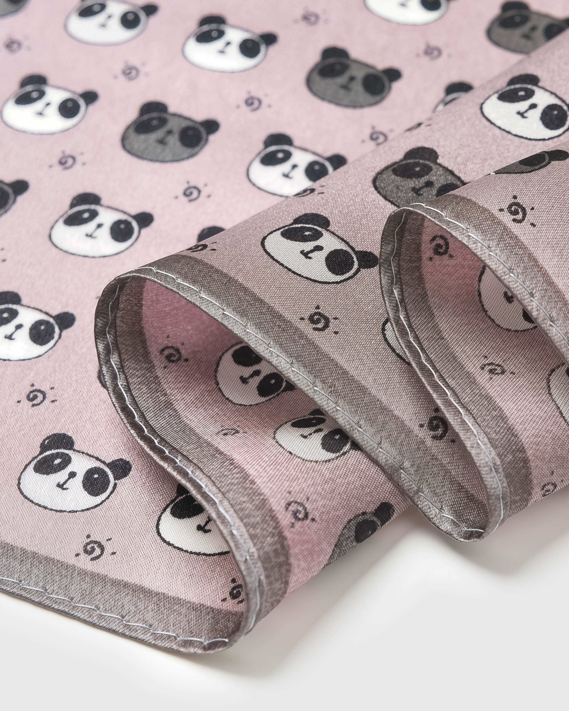Close-up of hand-illustrated panda heads printed in archival ink on blush pink silk