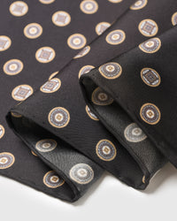 Close-up of the hand-illustrated coin medallions printed in archival inks on pure black silk
```