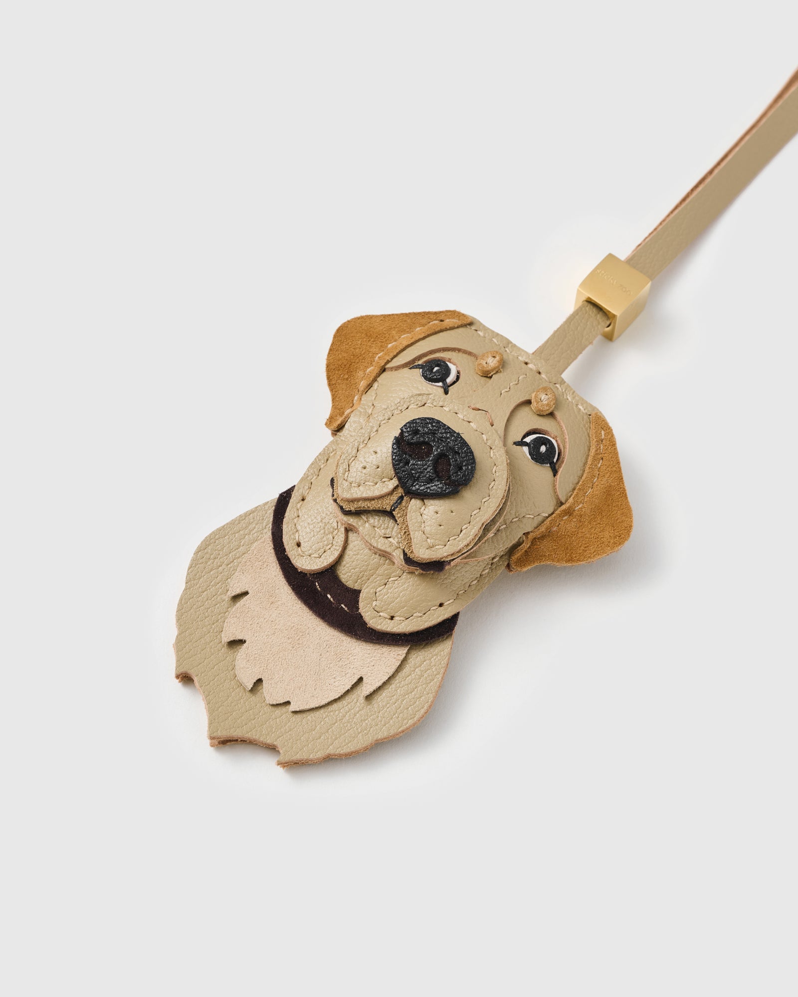 {{Hand-cut. Hand-stitched.}} Close-up of the Labrador Retriever face, angled — layered muzzle, stitched lip lines, Labrador suede ears, dark nose. Every panel by hand.