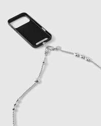 Silver-tone dual clasps and engraved disc connecting the ball-bead strap to a black phone case, hearts and clusters running down the chain.