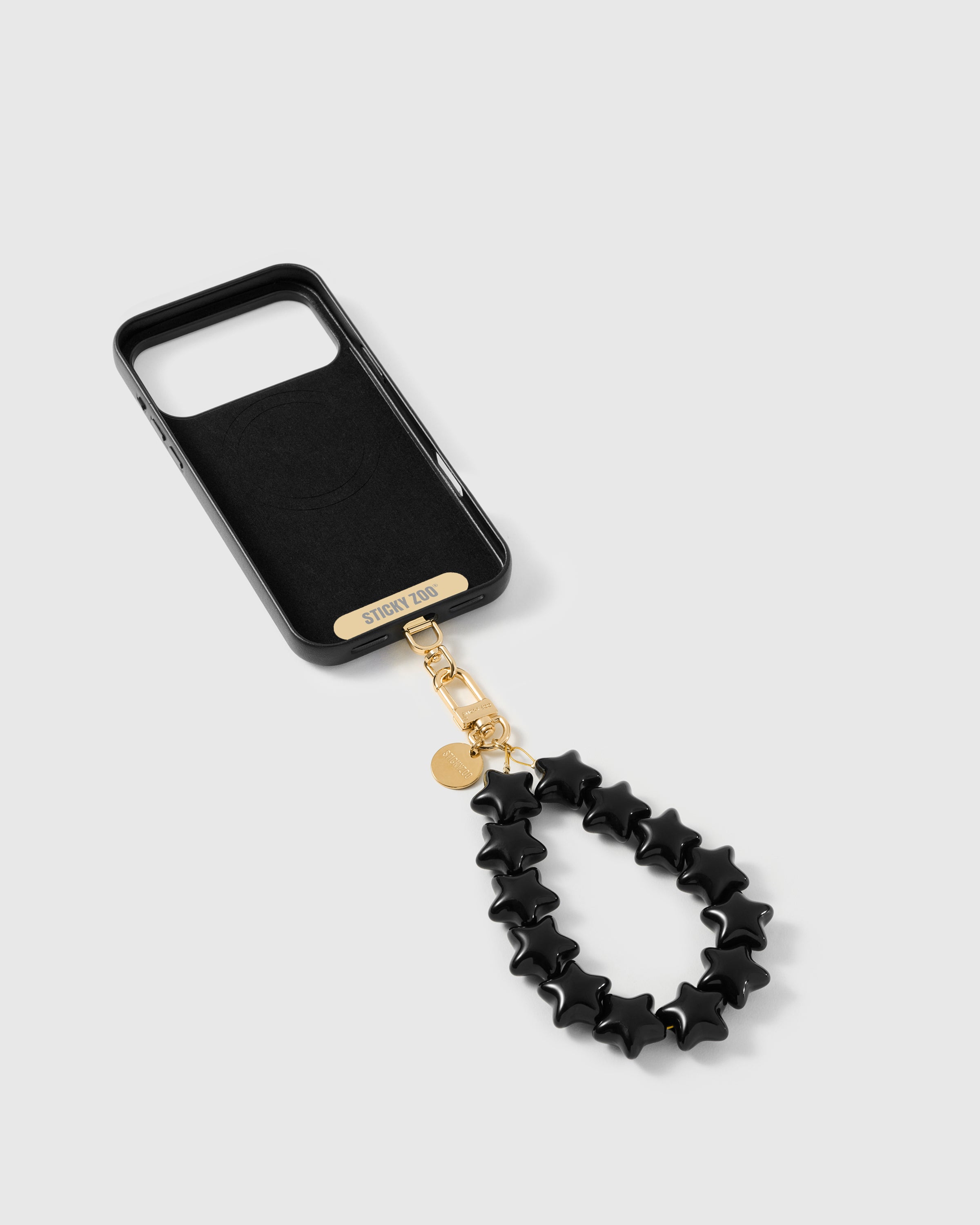 Phone Strap Card tucked inside phone case with noir star strap attached — universal fit