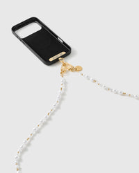 Black phone case with the pearl-and-gold strap draping from its 18K gold-plated dual clasps, gold STICKYZOO phone strap card visible at the case base.
