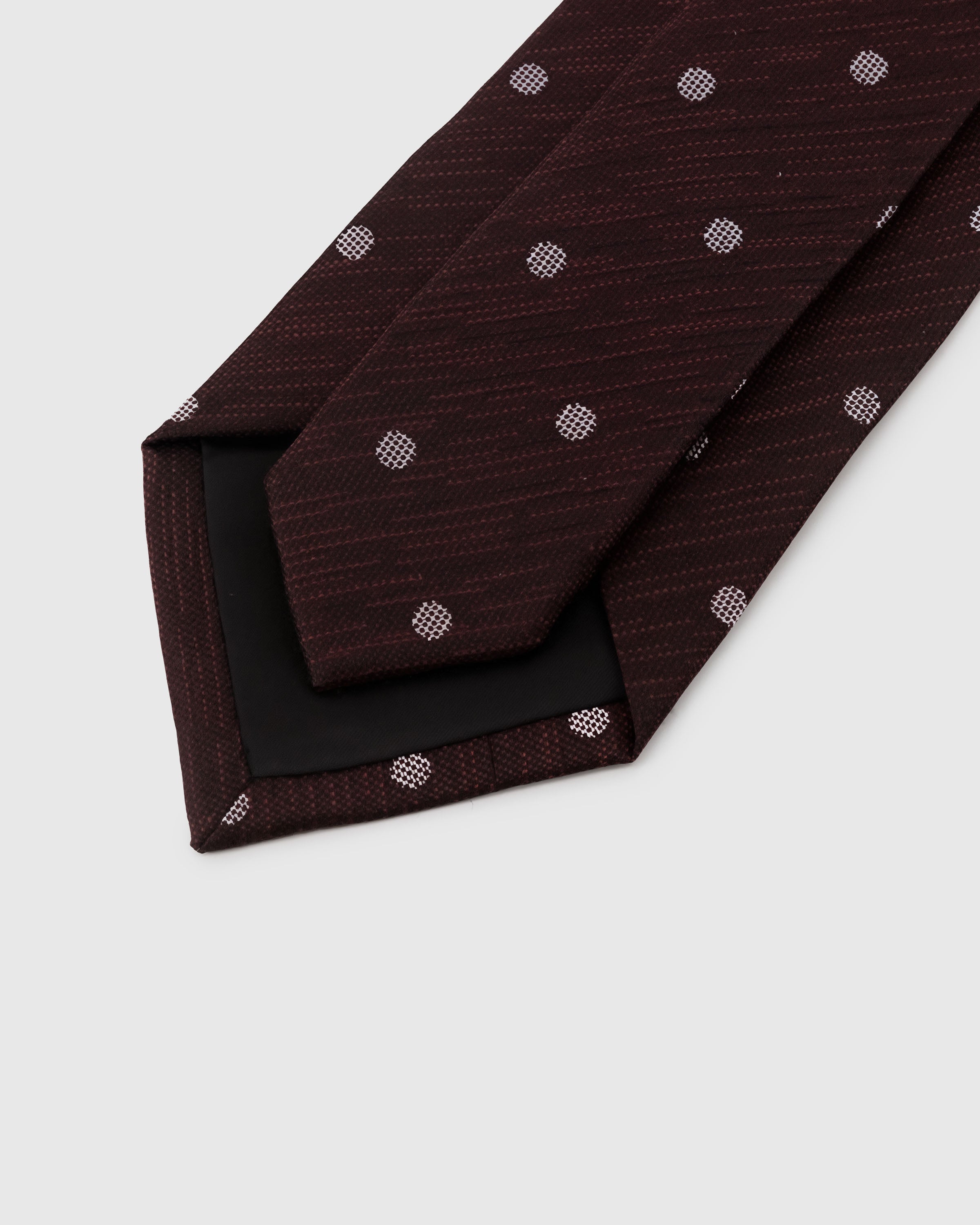 STICKYZOO Claret Dot Tie back detail showing black interlining and hand-finished slip stitching, 145 × 8 cm