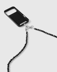 Faceted black beaded strap clipped to a black phone case, silver-tone clasp and disc, beads flowing down toward the floor.