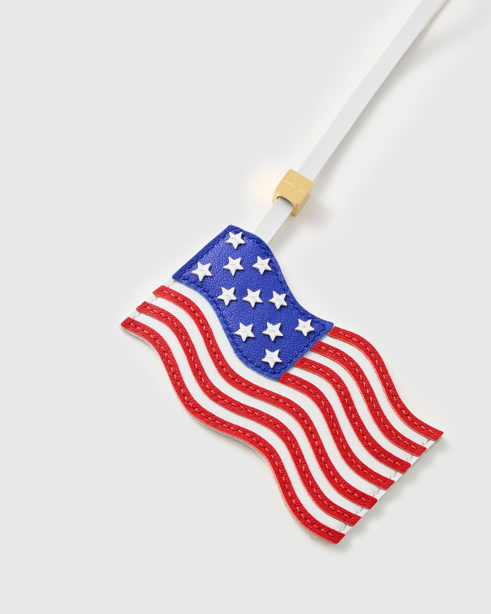 {{Stars and Stripes in leather}} Close-up of handmade USA flag charm showing individually hand-cut white leather stars on blue canton