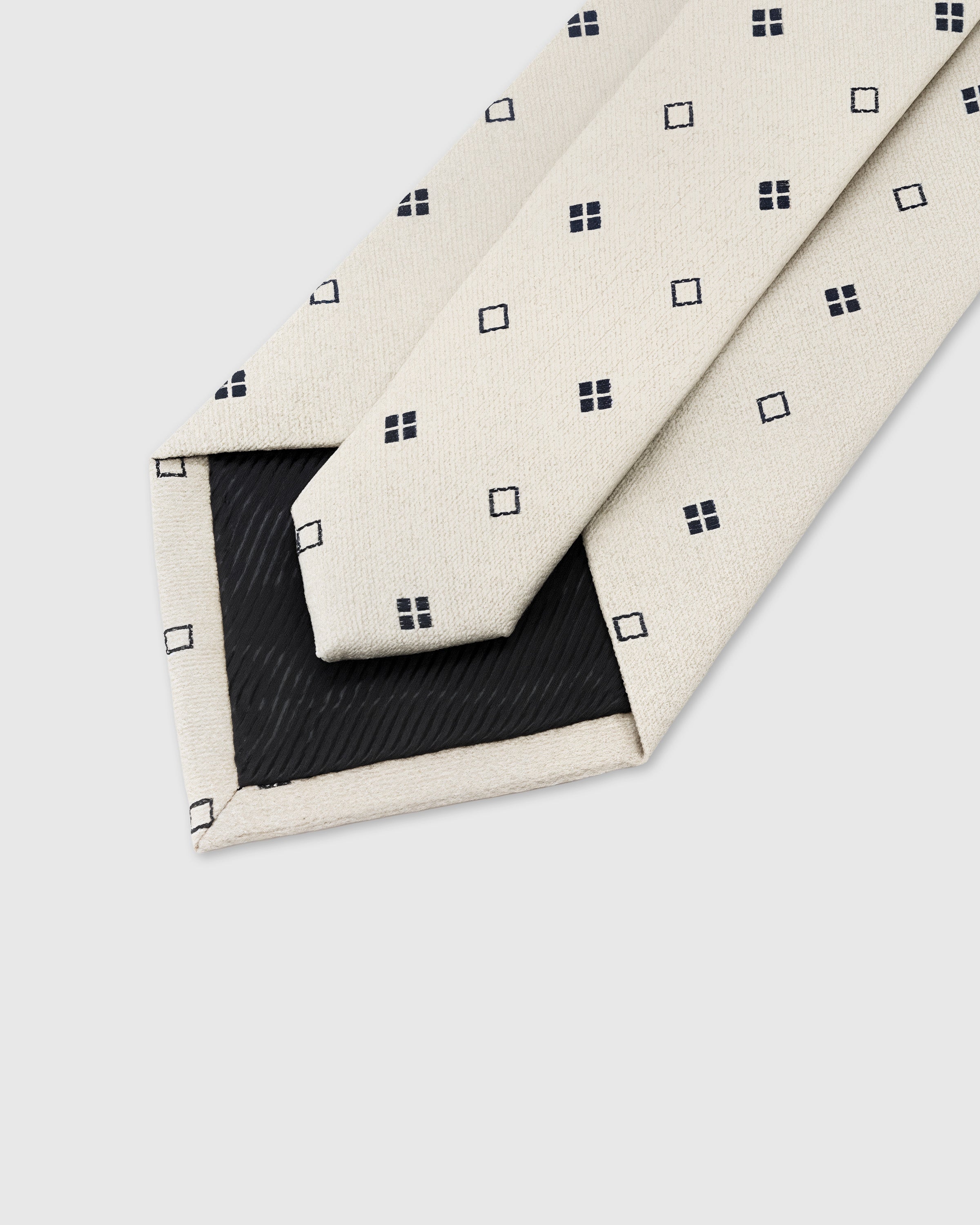 STICKYZOO Pearl Square Dot Tie construction detail showing 45° bias-cut Italian method and structured interlining, rated 4.9 stars