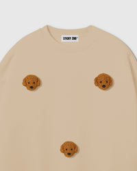 Close-up of hand-stitched plush poodle face showing curly golden fur on beige cotton