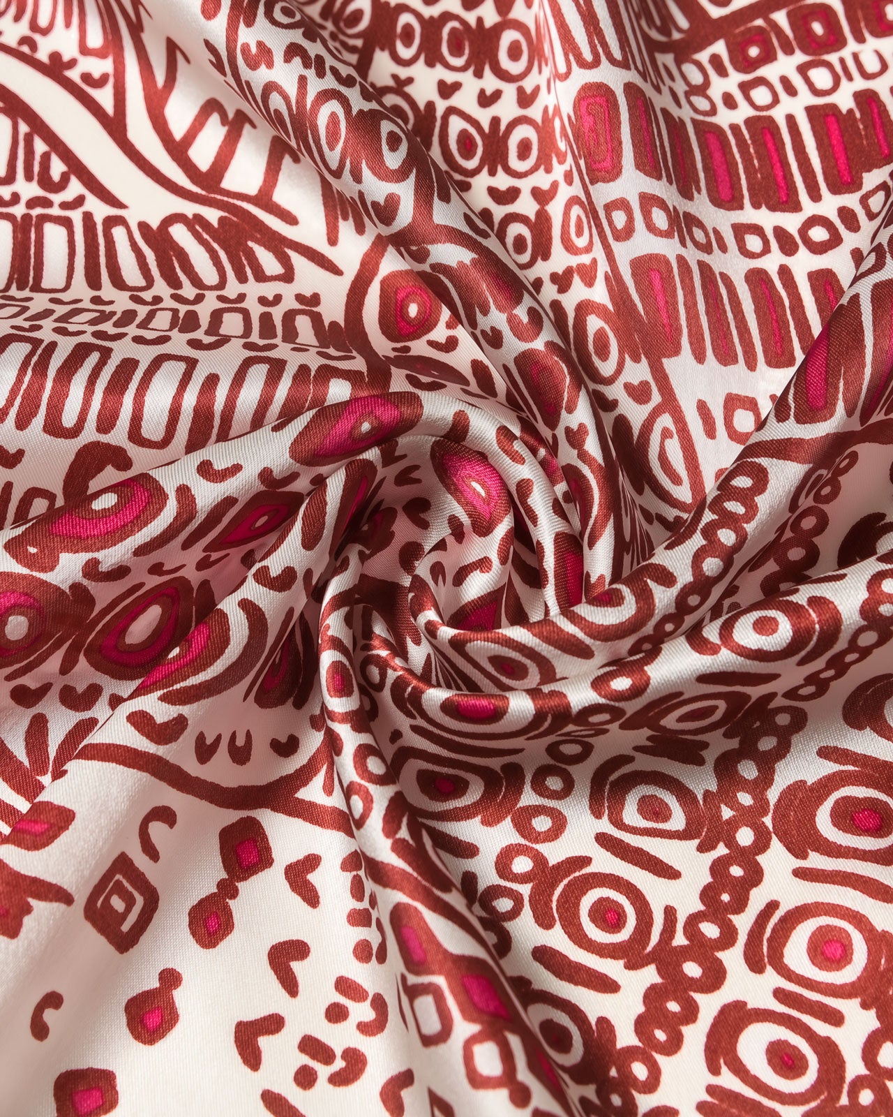 STICKYZOO crimson folklore silk scarf coiled to show the hand-illustrated print and magenta accents on cream