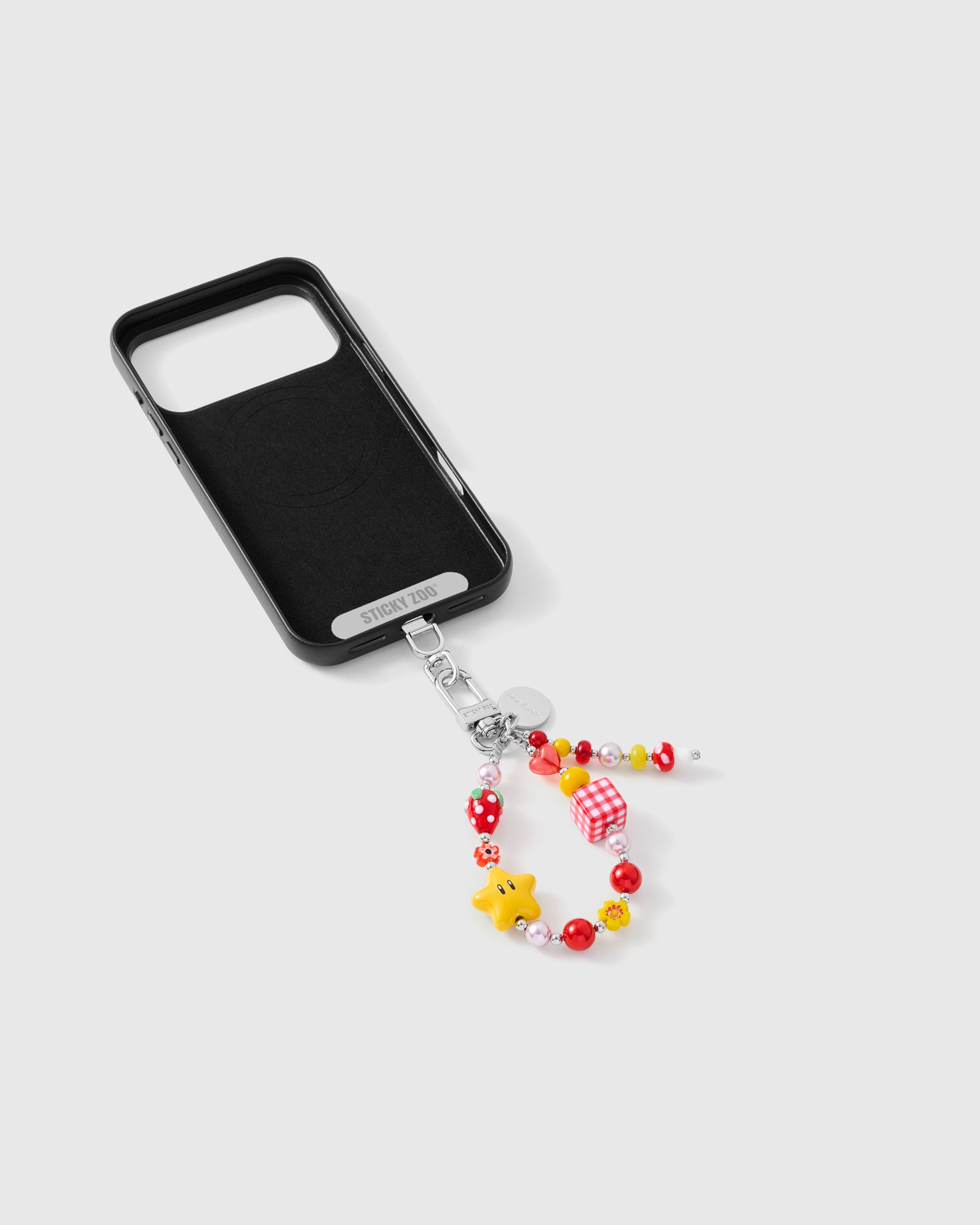 {{Strap Card included}} Inside of phone case showing STICKYZOO Phone Strap Card with charm cluster strap attached