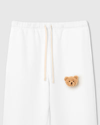 Close-up of plush teddy bear face applique on white cotton fleece showing sherpa texture and embroidered detail