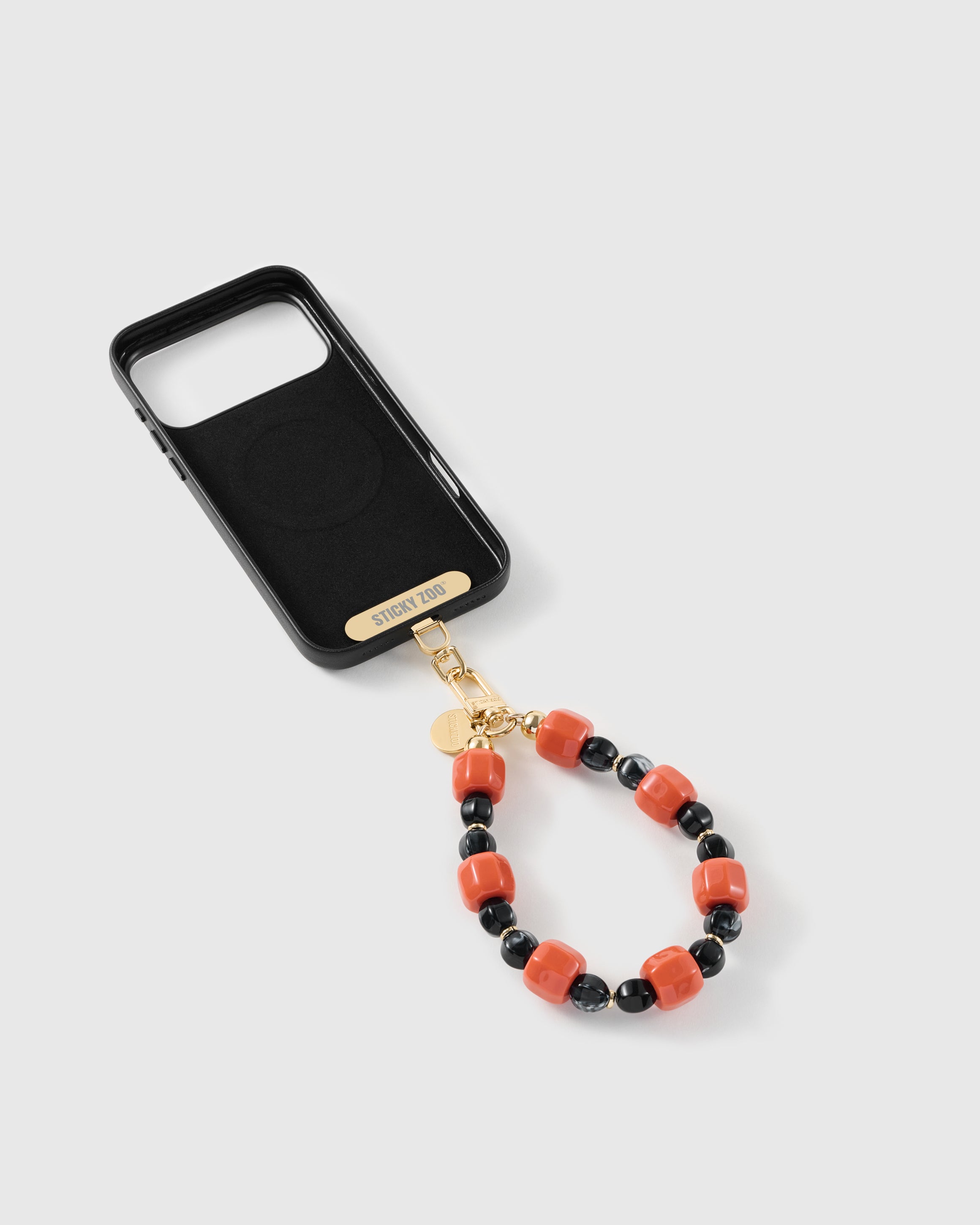 Ember-orange and black bead strap attached to a phone case with the included Phone Strap Card