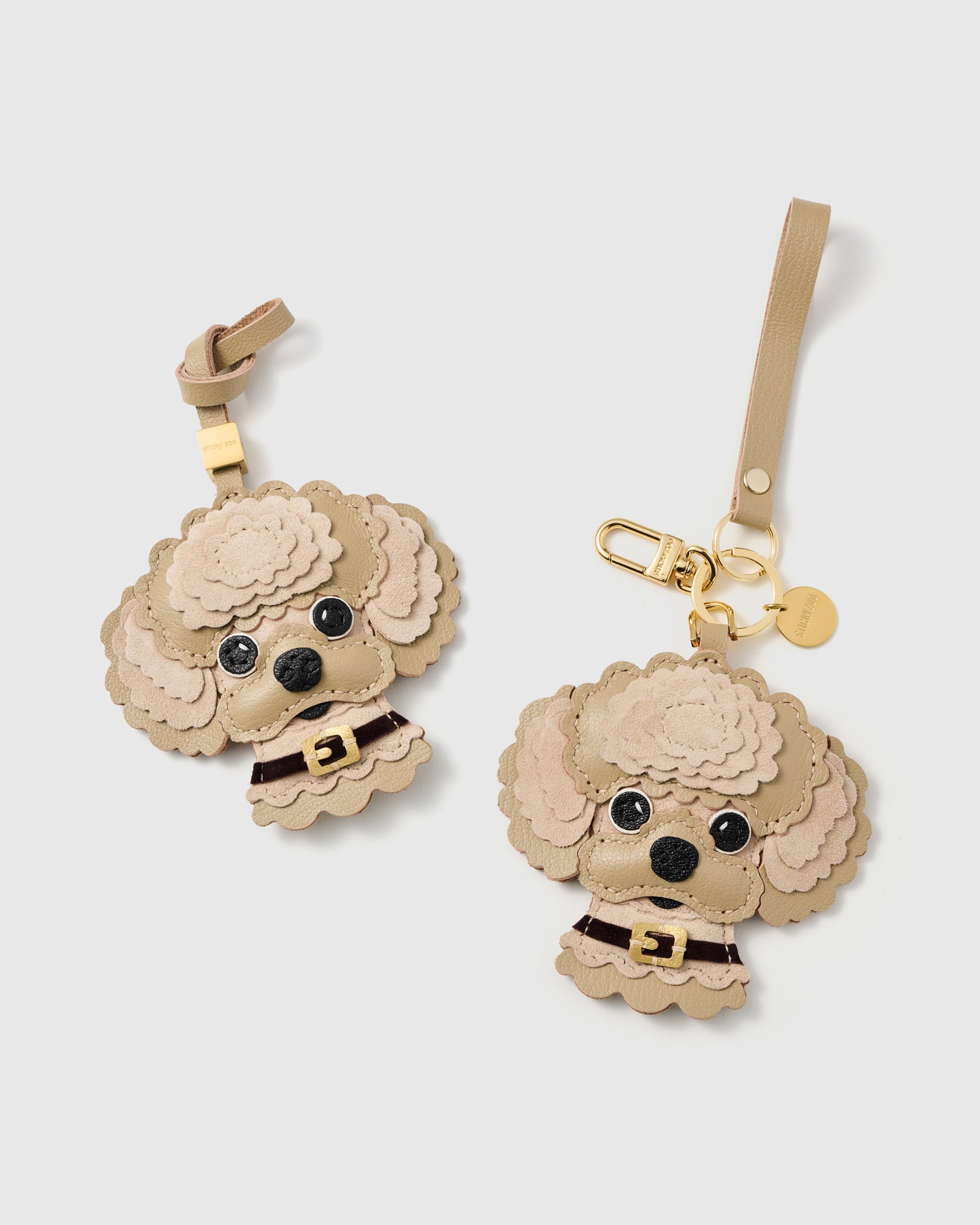 {{Strap or clip. You choose.}} both cream editions — leather strap loop and 18K gold-plated keychain clip. Same handmade French Alran goatskin and alcantara suede charm, two ways to carry.