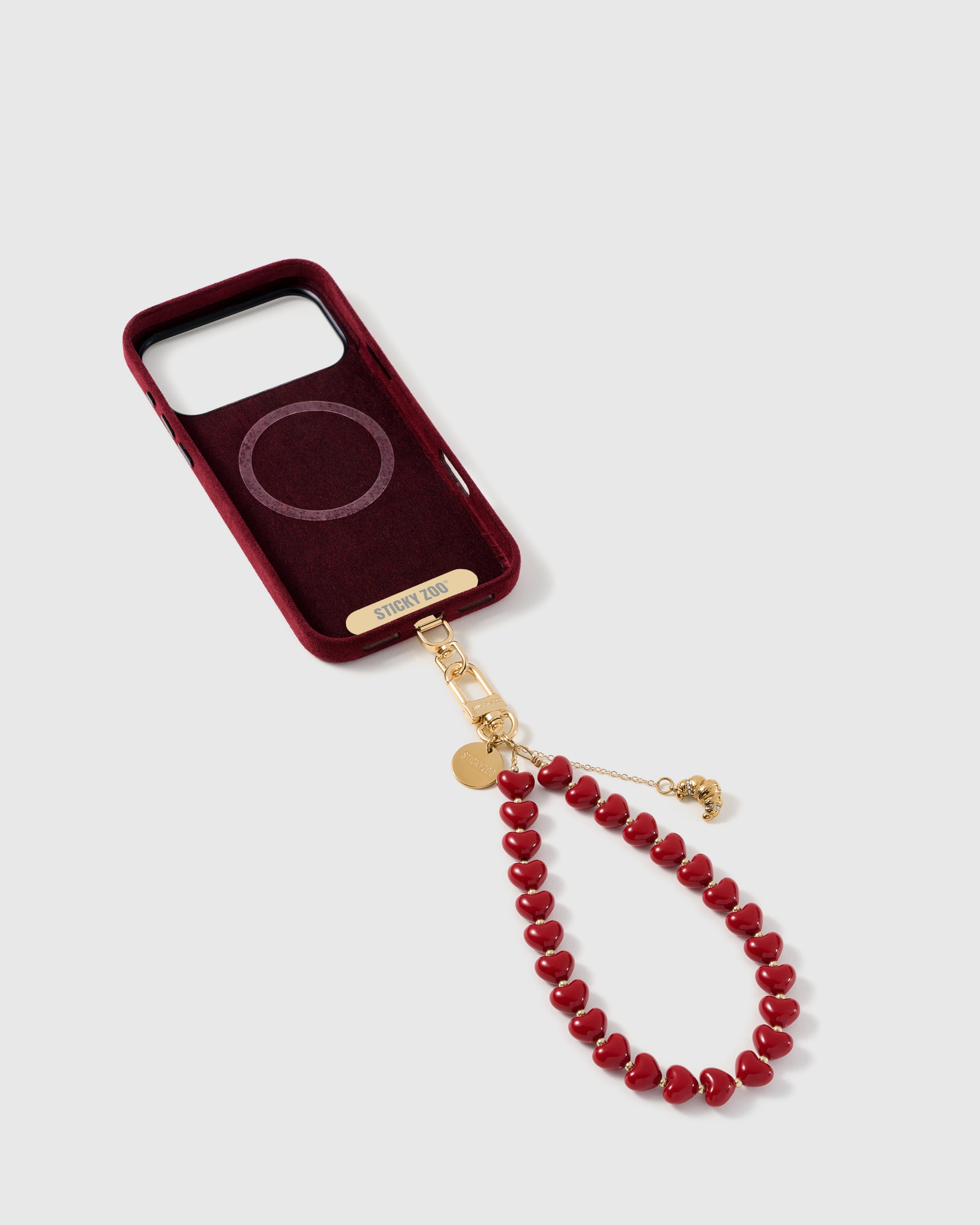 Phone Strap Card tucked inside phone case with cherry croissant heart strap attached — universal fit