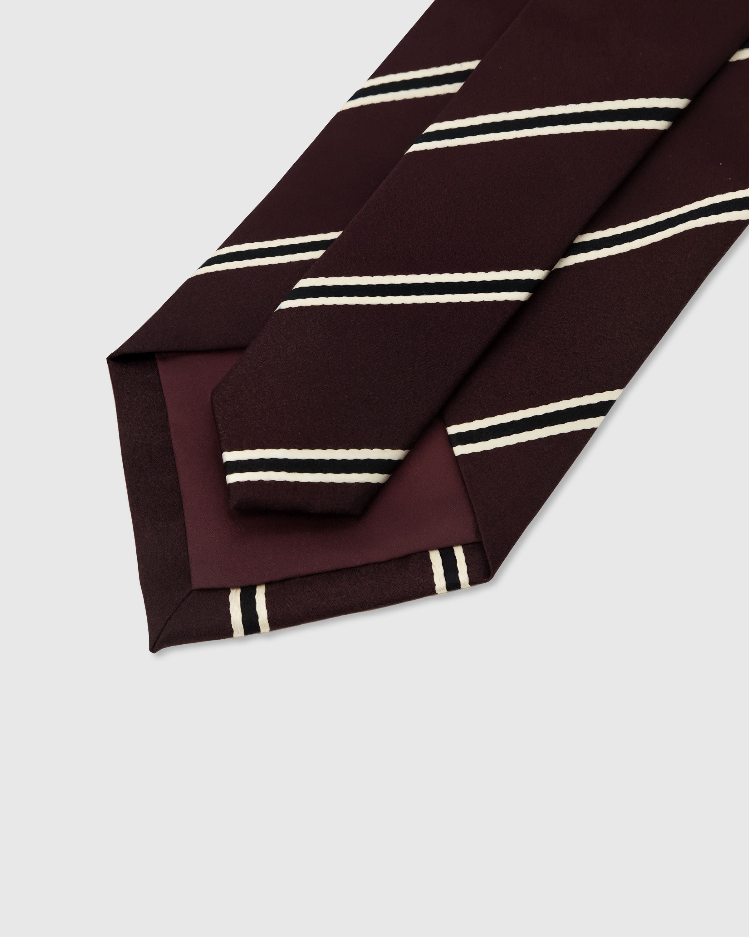 STICKYZOO Oxblood Regimental Tie construction detail showing 45° bias cut, structured interlining and slip stitching, 145 x 8 cm