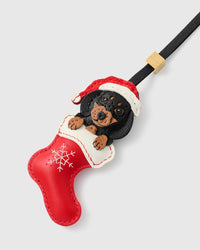 Close-up of handmade Santa Dachshund Stocking bag charm — hand-cut white-trimmed Santa hat in French Alran goatskin, embroidered eyes on dachshund face. STICKYZOO holiday collectible.