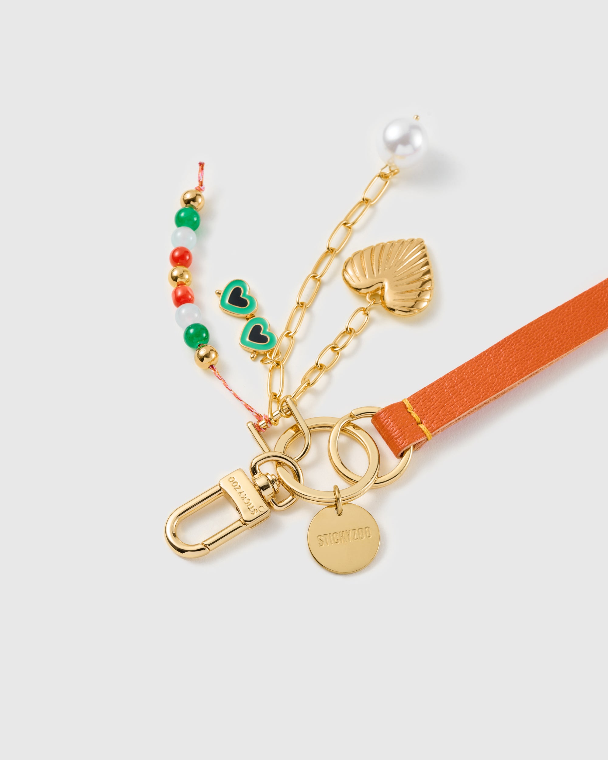 Charm trio leather phone strap clipped to a phone case showing the hands-free wrist loop in use