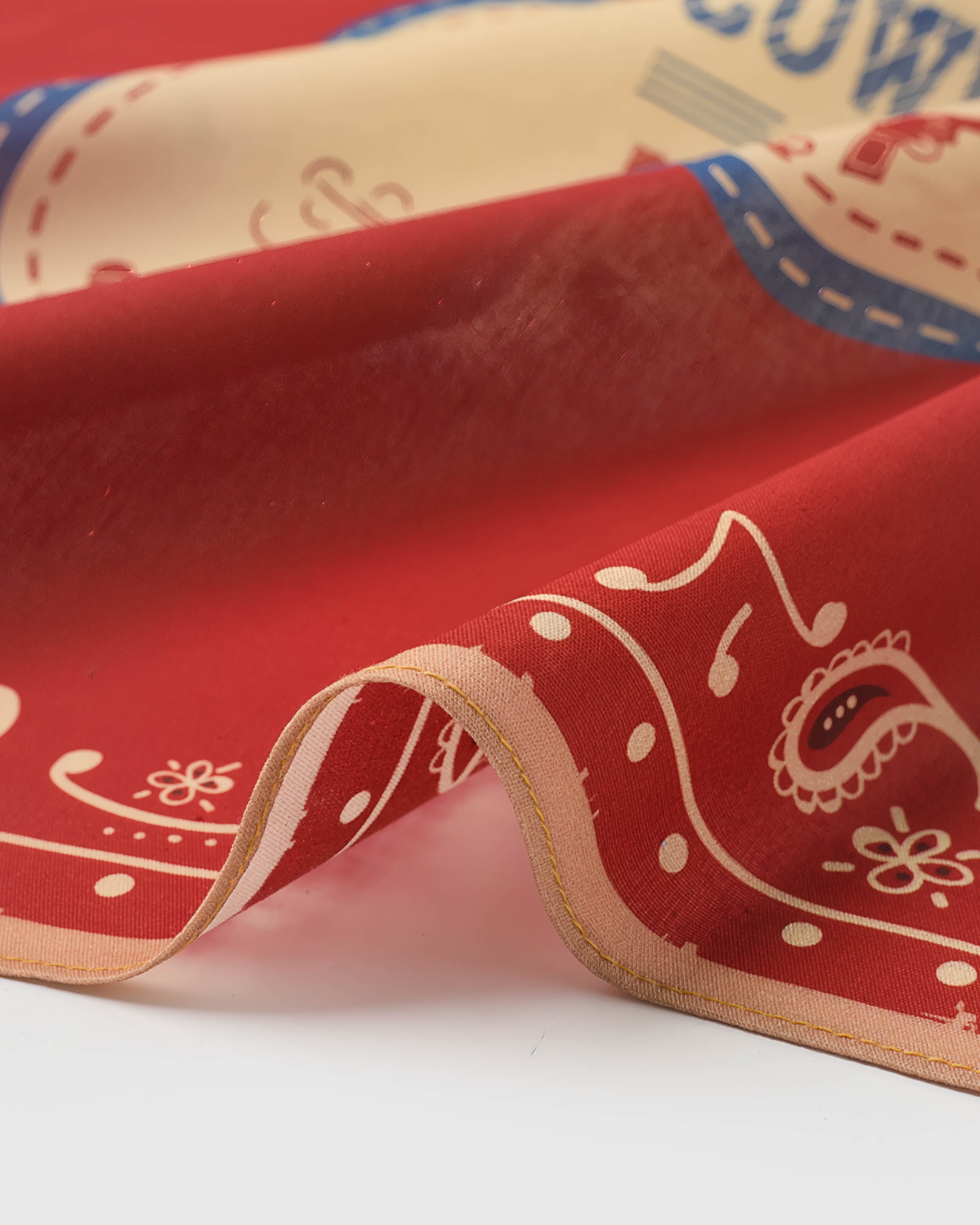 Close-up of the rodeo paisley silk scarf showing the cinnabar drape and printed paisley corners