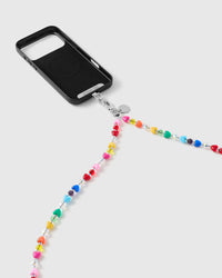 Black phone case with the multicolour heart-bead strap draping from a silver-tone clasp and engraved disc against a soft grey backdrop.