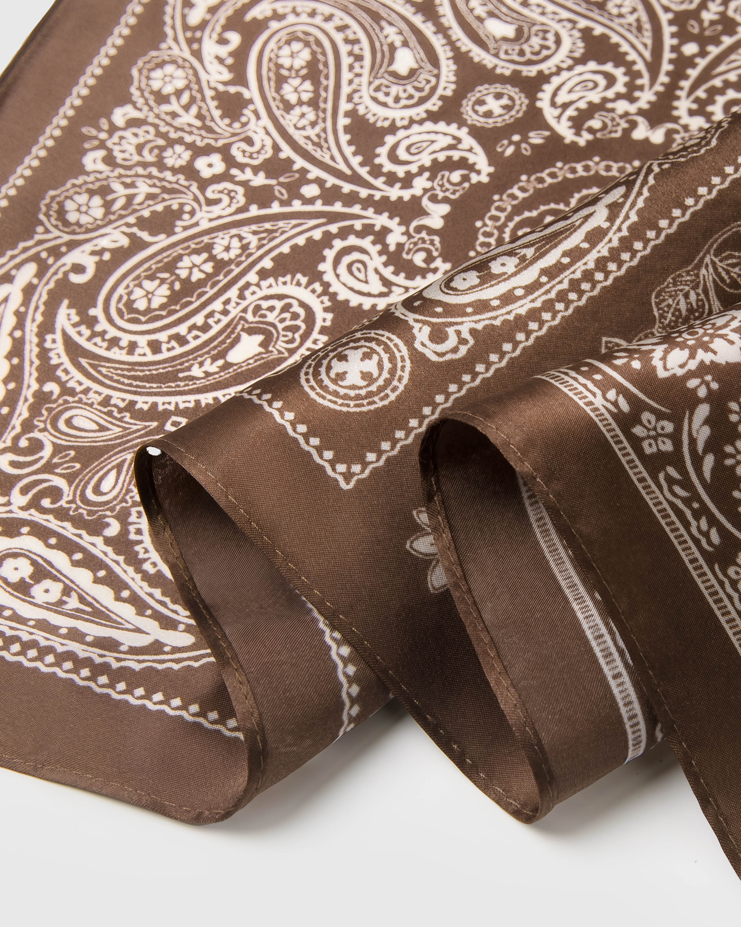 Close-up of the cocoa silk edge and the hand-illustrated paisley showing archival ink saturation