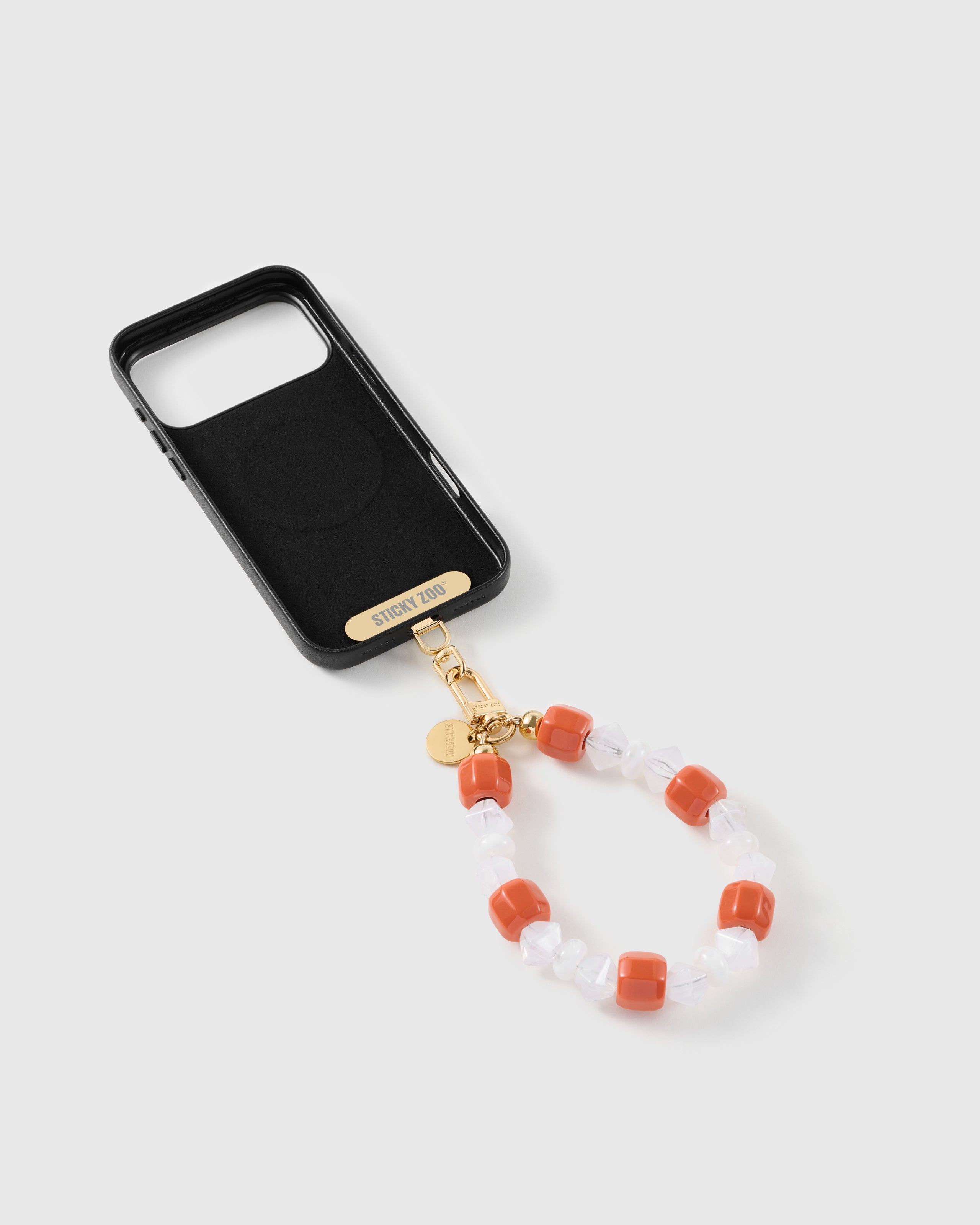 Clementine-orange bead strap attached to a phone case with the included Phone Strap Card