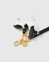 Close-up of the hand-stitched black-and-white leather dog charm and engraved STICKYZOO gold hardware