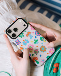 Back of the pixel mushroom phone case showing 8-bit florals and mushrooms on UV-printed cream ABS