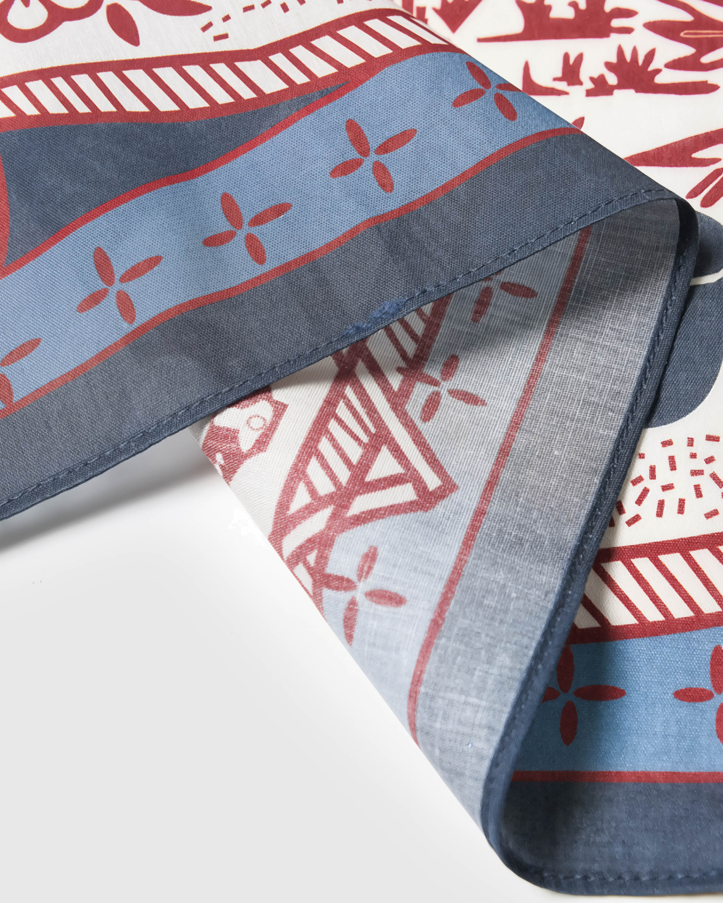 Close-up of the slate-blue rope-knot border meeting the cream silk field