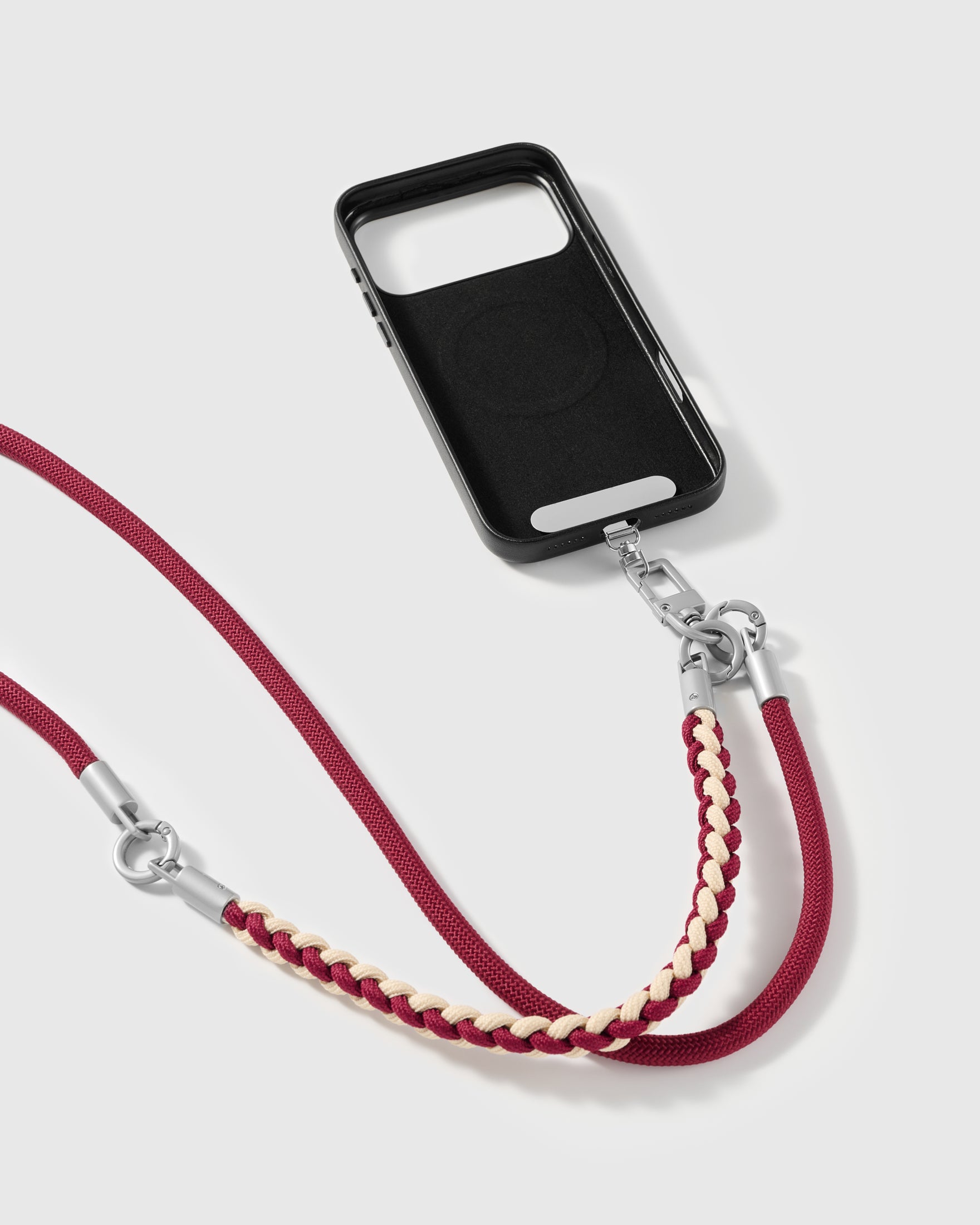 Burgundy cross-body phone strap clipped to a phone case for hands-free carry
