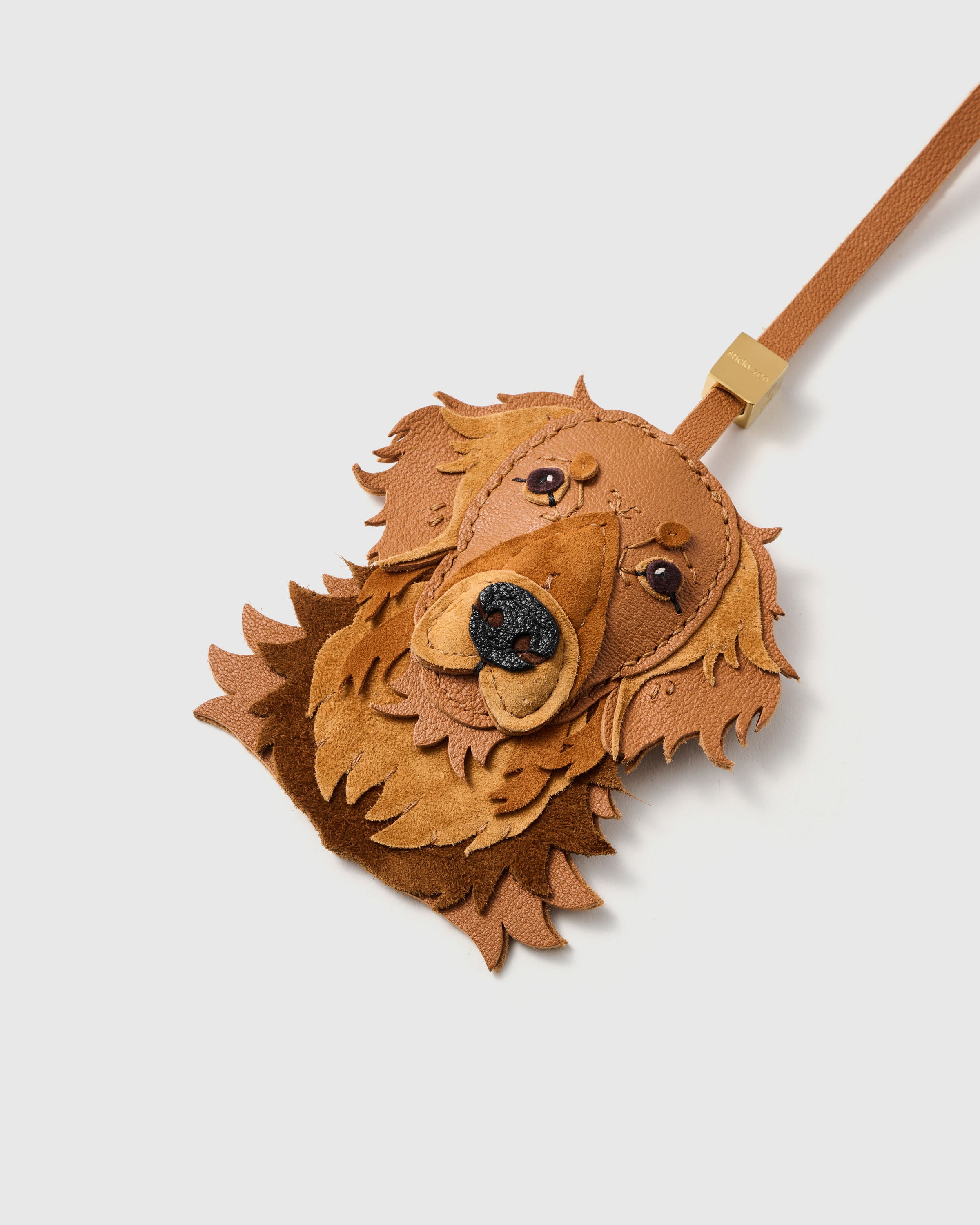 {{Hand-cut. Hand-stitched.}} layered toffee leather muzzle, alcantara suede chest, textured black nose, glass eyes. Every panel cut and shaped by hand.