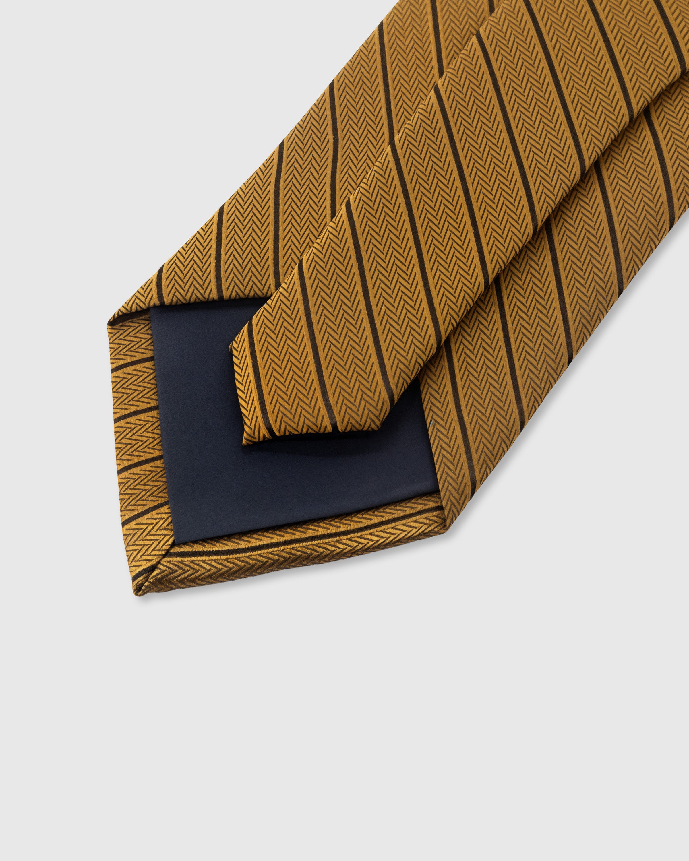 STICKYZOO Amber Herringbone Tie showing 45° bias-cut Italian method construction and natural silk drape, 145 × 8 cm