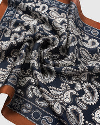 Close-up of the hand-illustrated paisley motif in ivory and pearl on the navy silk field
