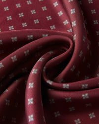 Close-up of the burgundy silk swirled to show the silver floret motif and the soft drape