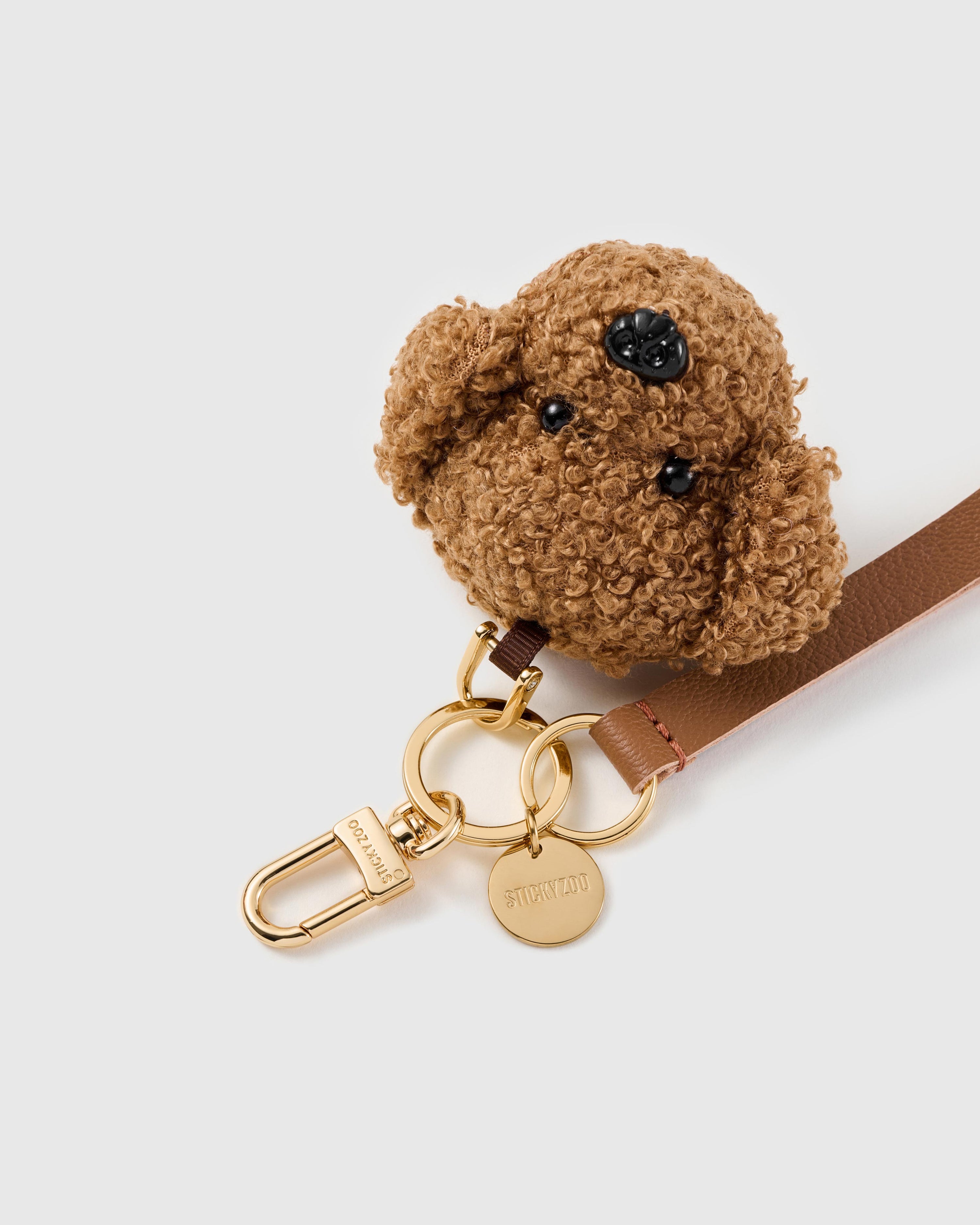 Teddy face leather phone strap clipped to a phone case showing the hands-free wrist loop in use