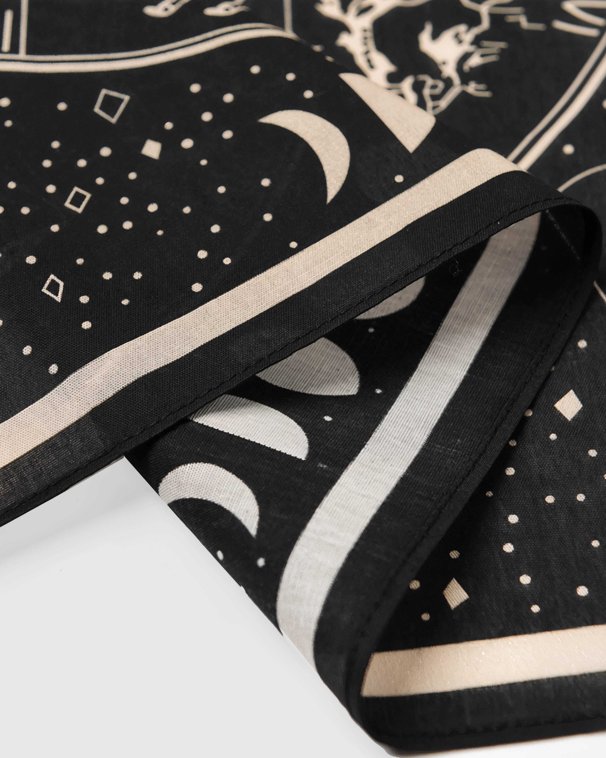 Close-up of the moon-phase border on the zodiac silk scarf showing the inked detail and silk weave
```