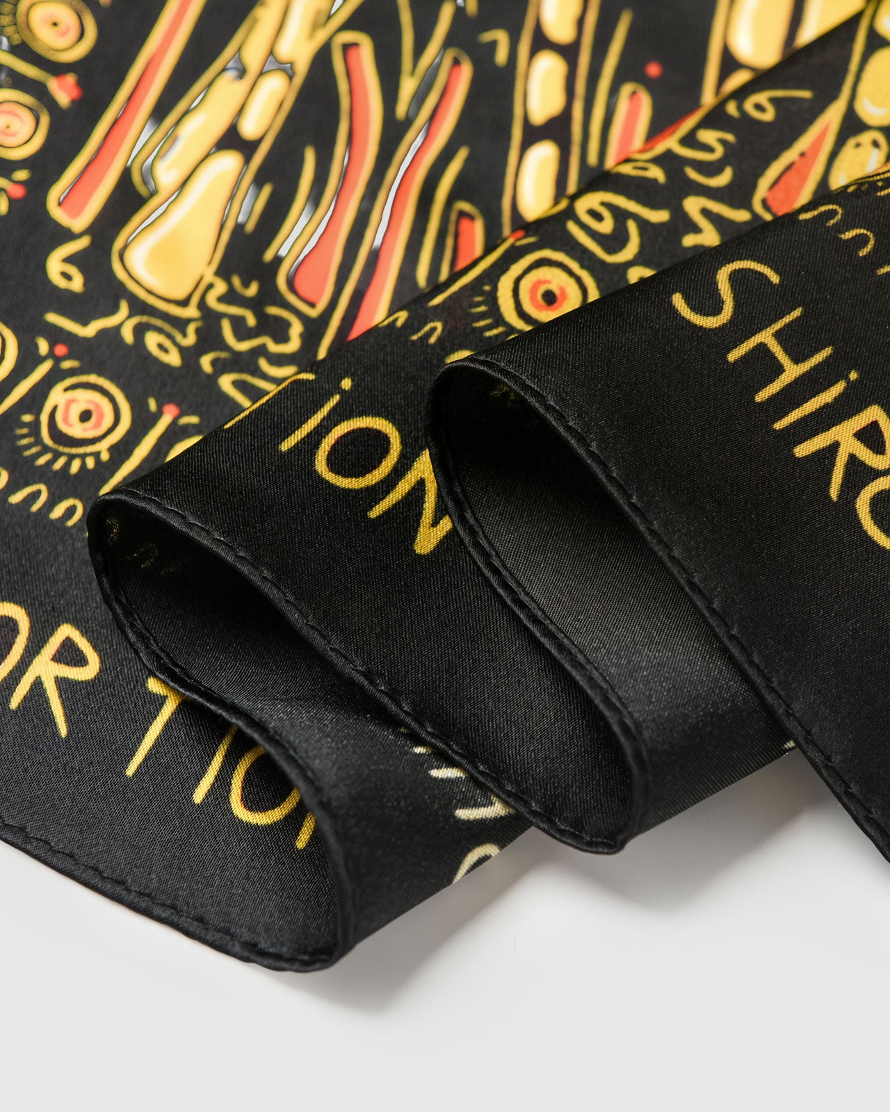 Close-up of the black silk scarf border and gold detail print showing the print sitting saturated on pure silk
```