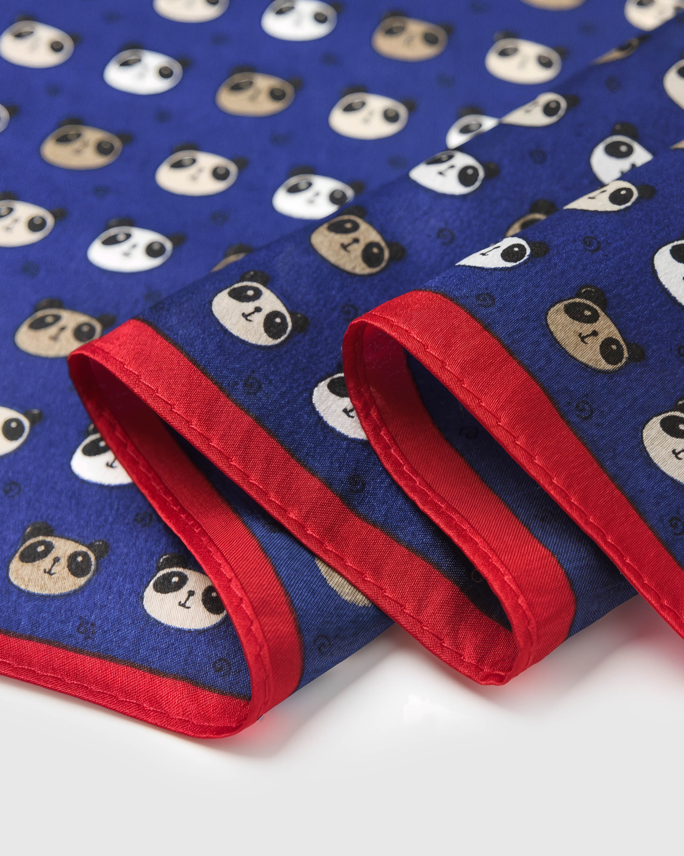 Close-up of the hand-illustrated panda motif printed in archival ink with the red-orange border meeting the navy field