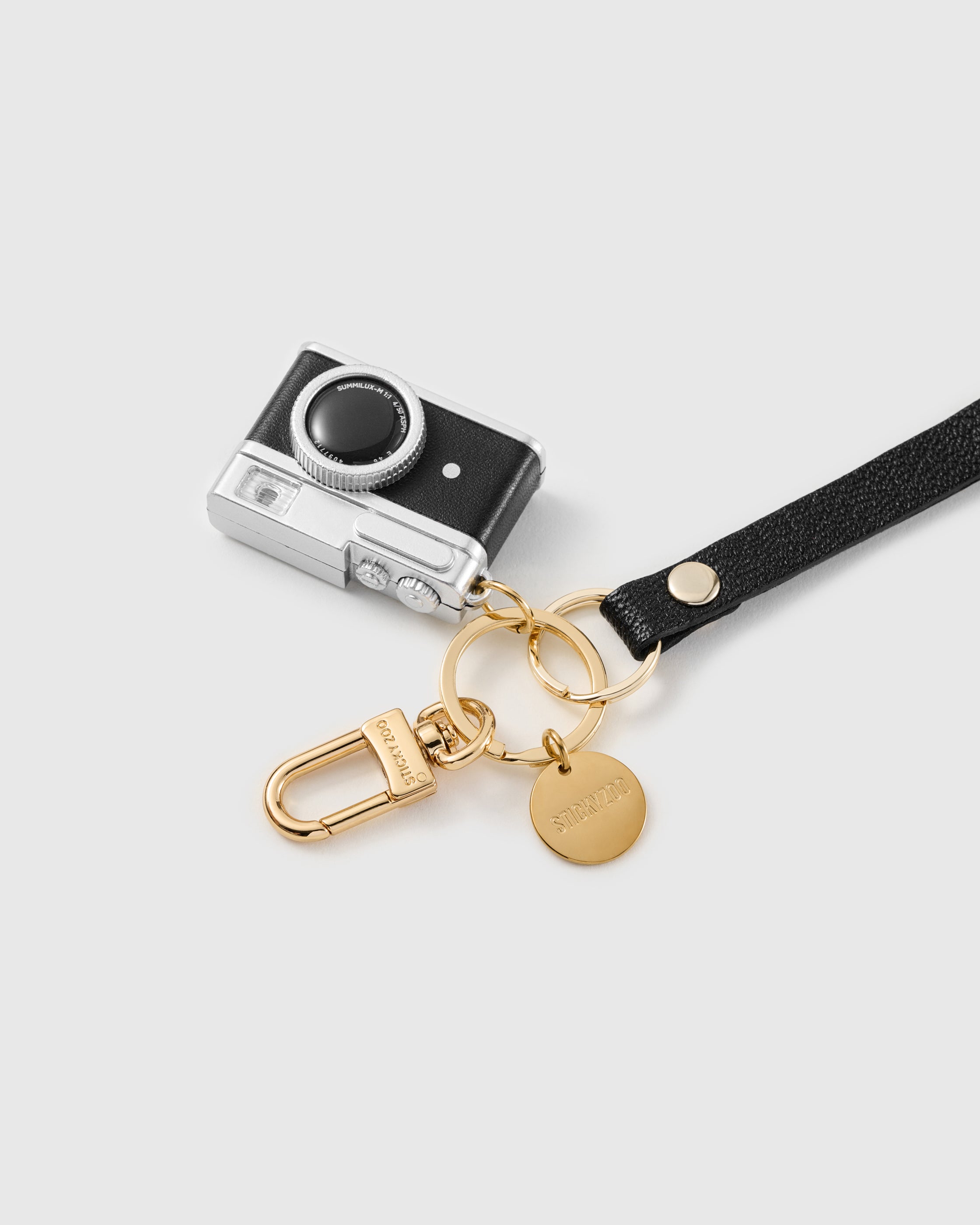 Noir camera leather phone strap clipped to a phone case showing the hands-free wrist loop in use