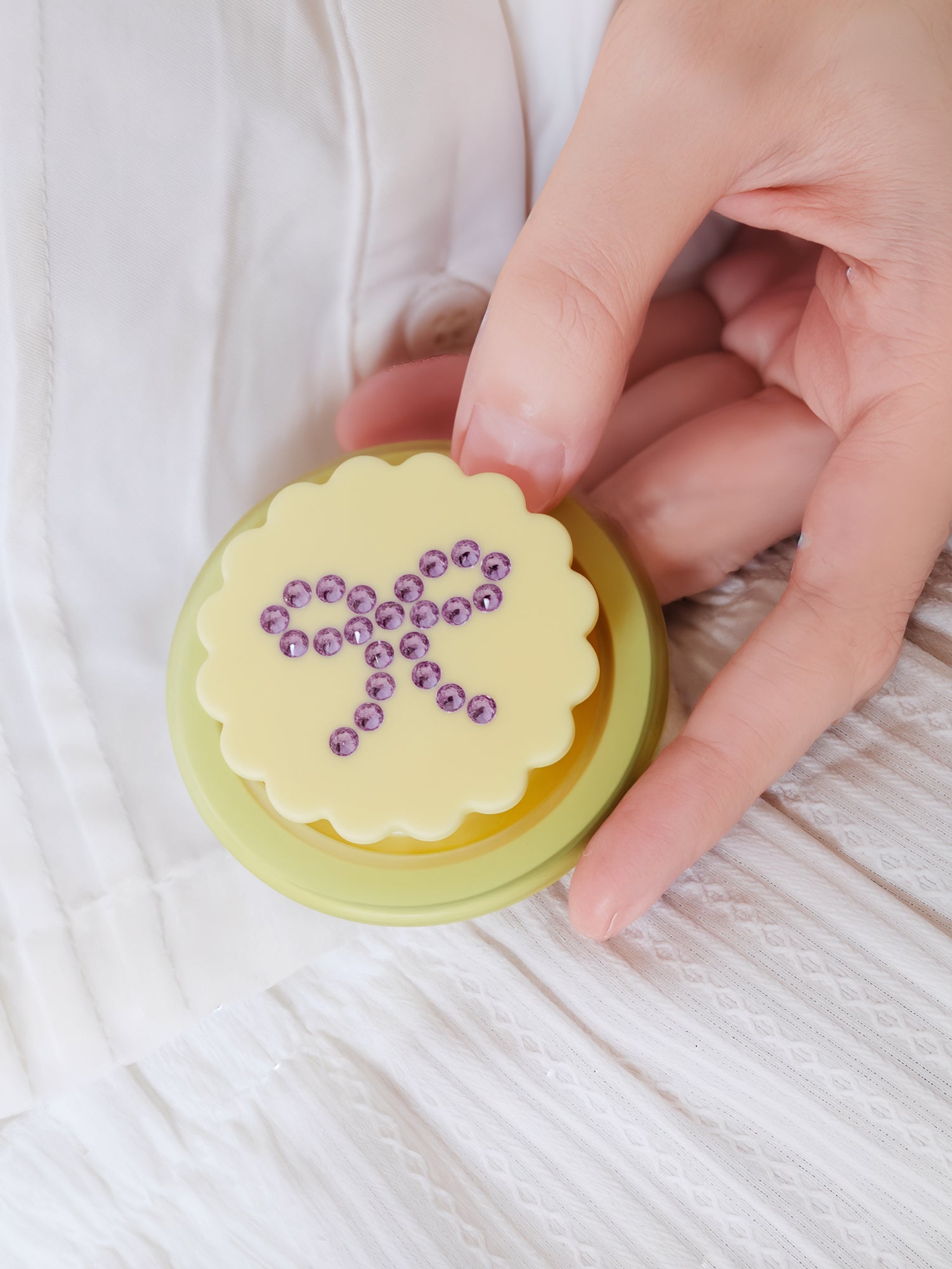 Close-up of the scalloped acrylic-resin grip medallion set with a lilac rhinestone bow on the butter bow case