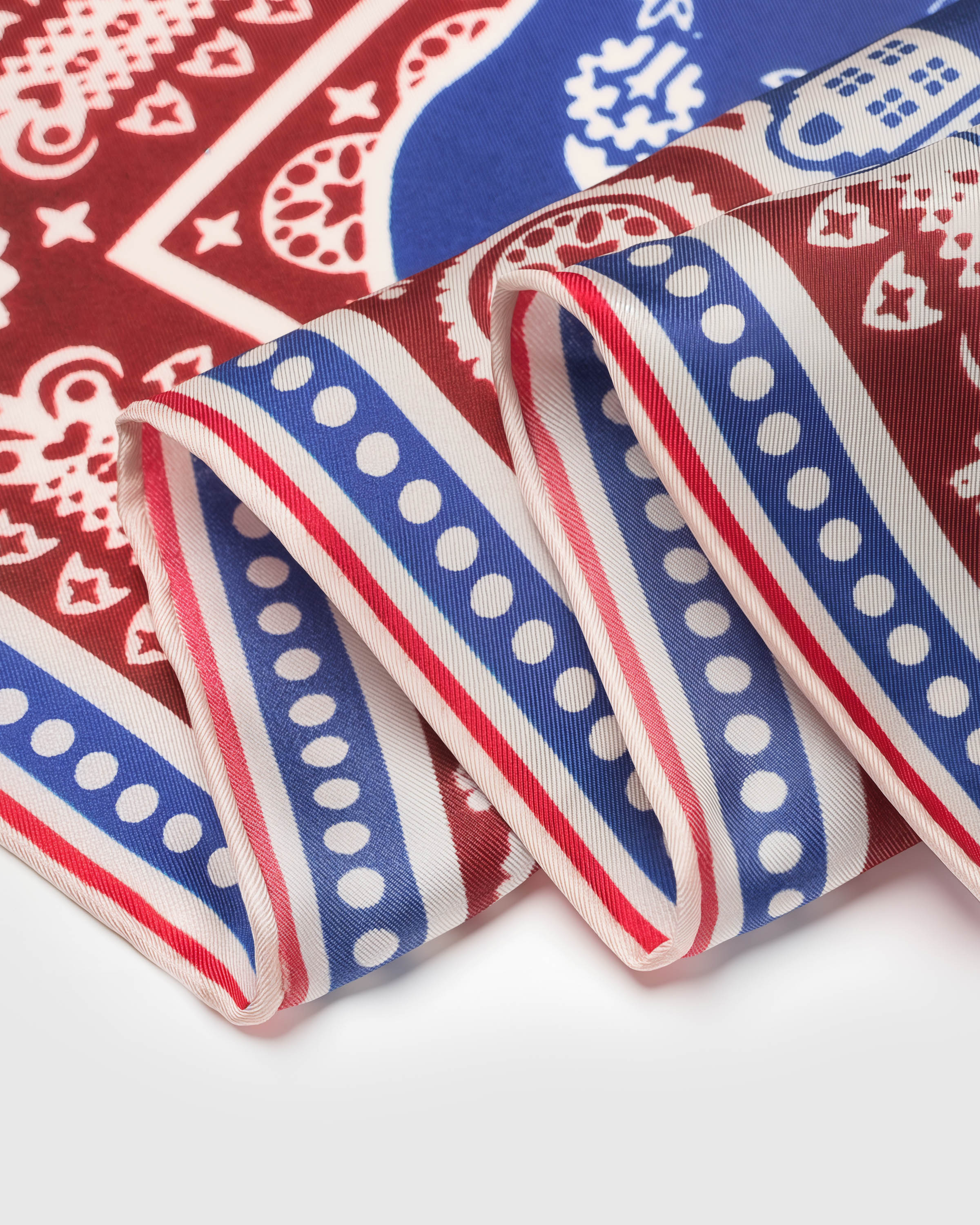 Close-up of the burgundy bandana border with paisley dots and stripes printed on pure silk