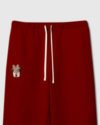 Close-up of plush reindeer face with felt antlers hand-stitched onto red cotton sweatpant