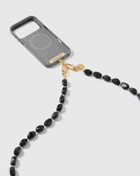 Dual-clasp black resin bead cross-body strap attached to a phone case with 18K gold-plated hooks