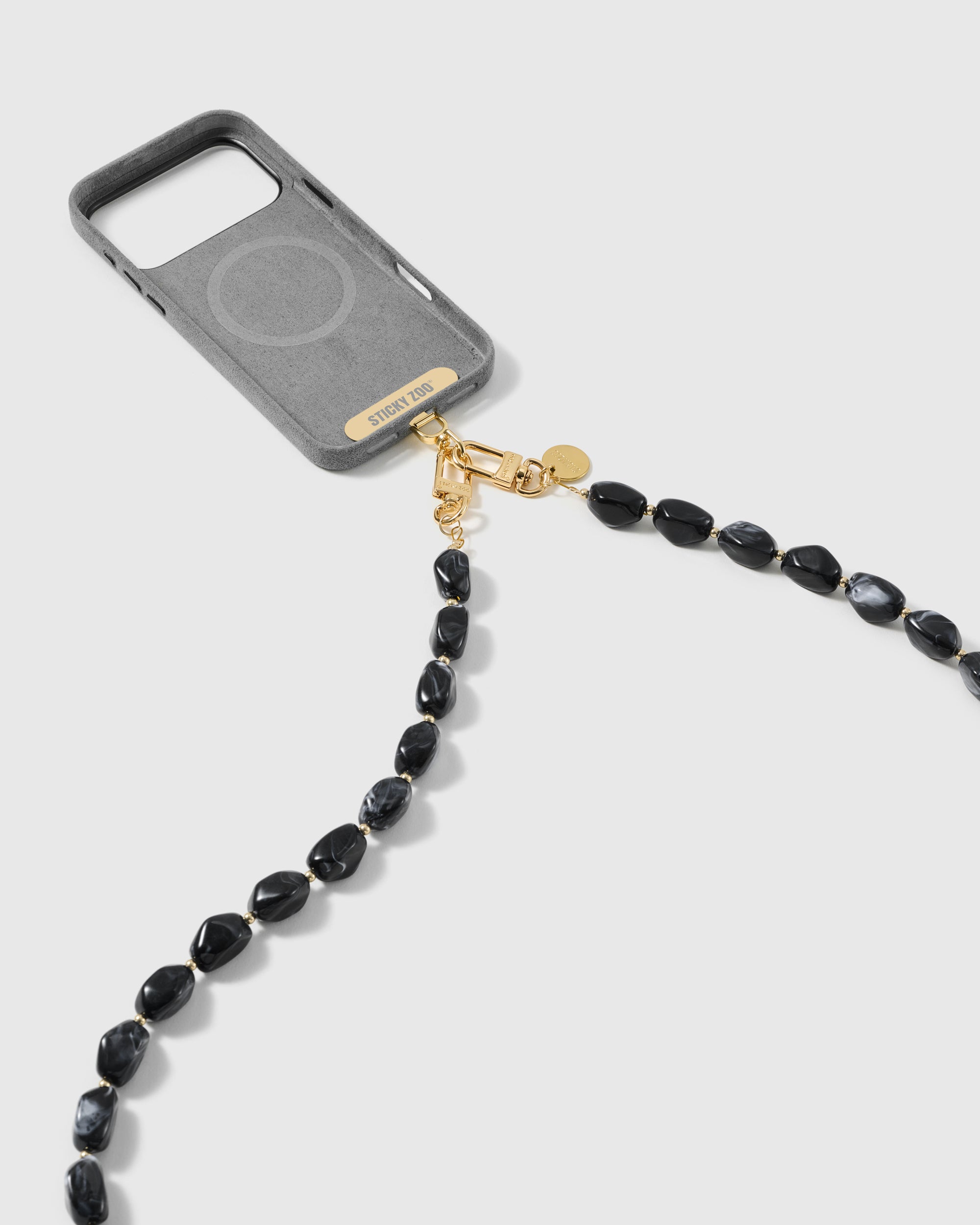 Dual-clasp black resin bead cross-body strap attached to a phone case with 18K gold-plated hooks