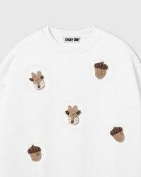 Close-up of hand-stitched plush reindeer with felt antlers on white cotton