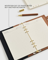 STICKYZOO A5 refill pages loaded in a leather ring notebook beside a wooden pen — never run out of pages, never buy another notebook.