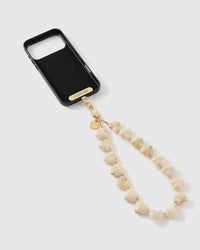 Black phone case with a gold STICKYZOO strap card and clasp, joined to a strand of marbled ivory heart beads with gold-tone spacers.