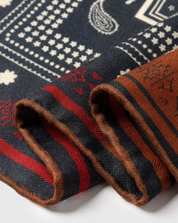 Edge detail of the saddle bandana silk scarf showing the red trim and rust border in pure silk