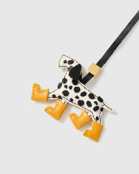 Close-up of handmade Dalmatian Rain Boots leather bag charm — individually hand-cut black spots on cream French Alran goatskin body. STICKYZOO 5-day build.
