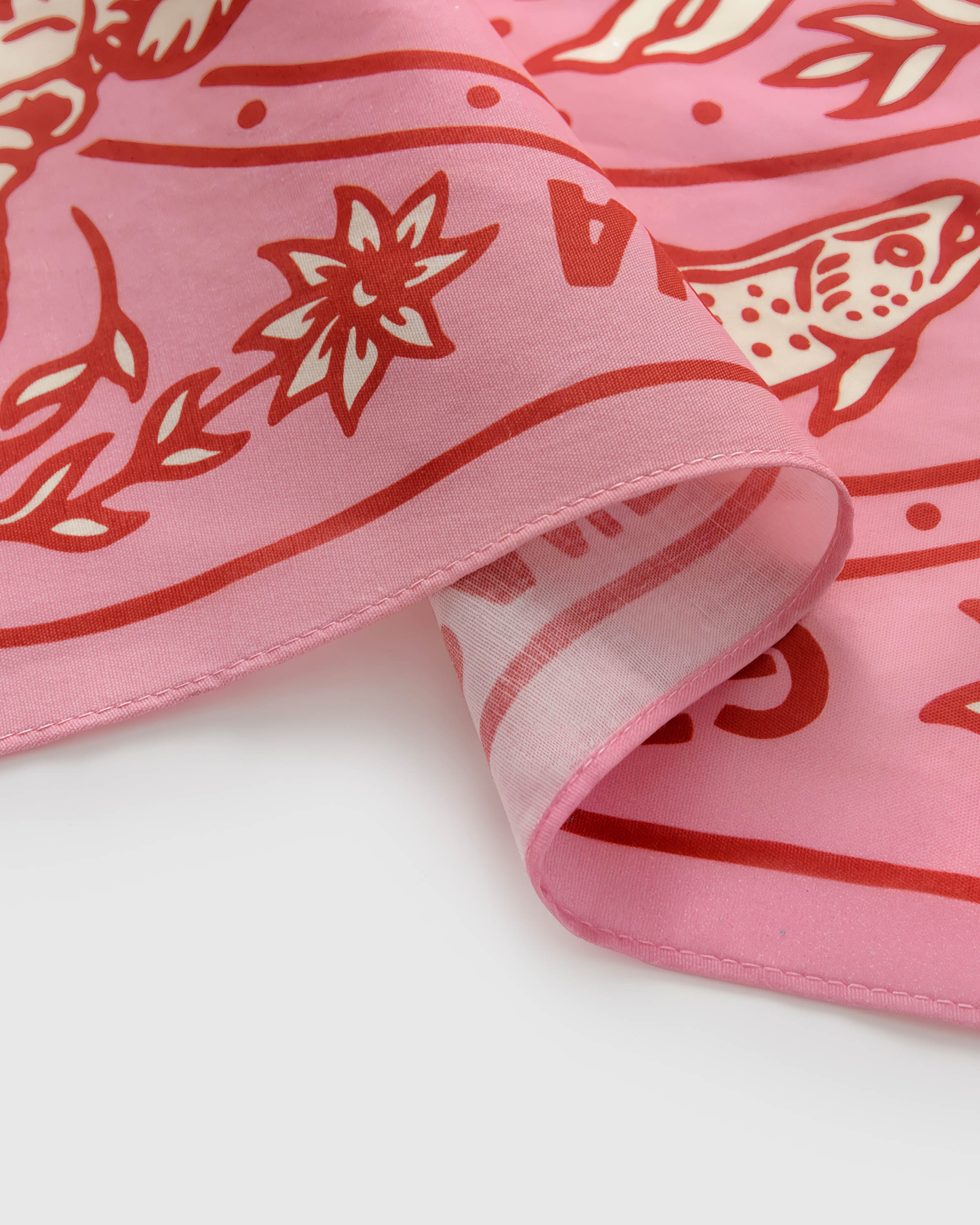 Print detail showing the hand-illustrated fox and star-flower motif on the pink silk