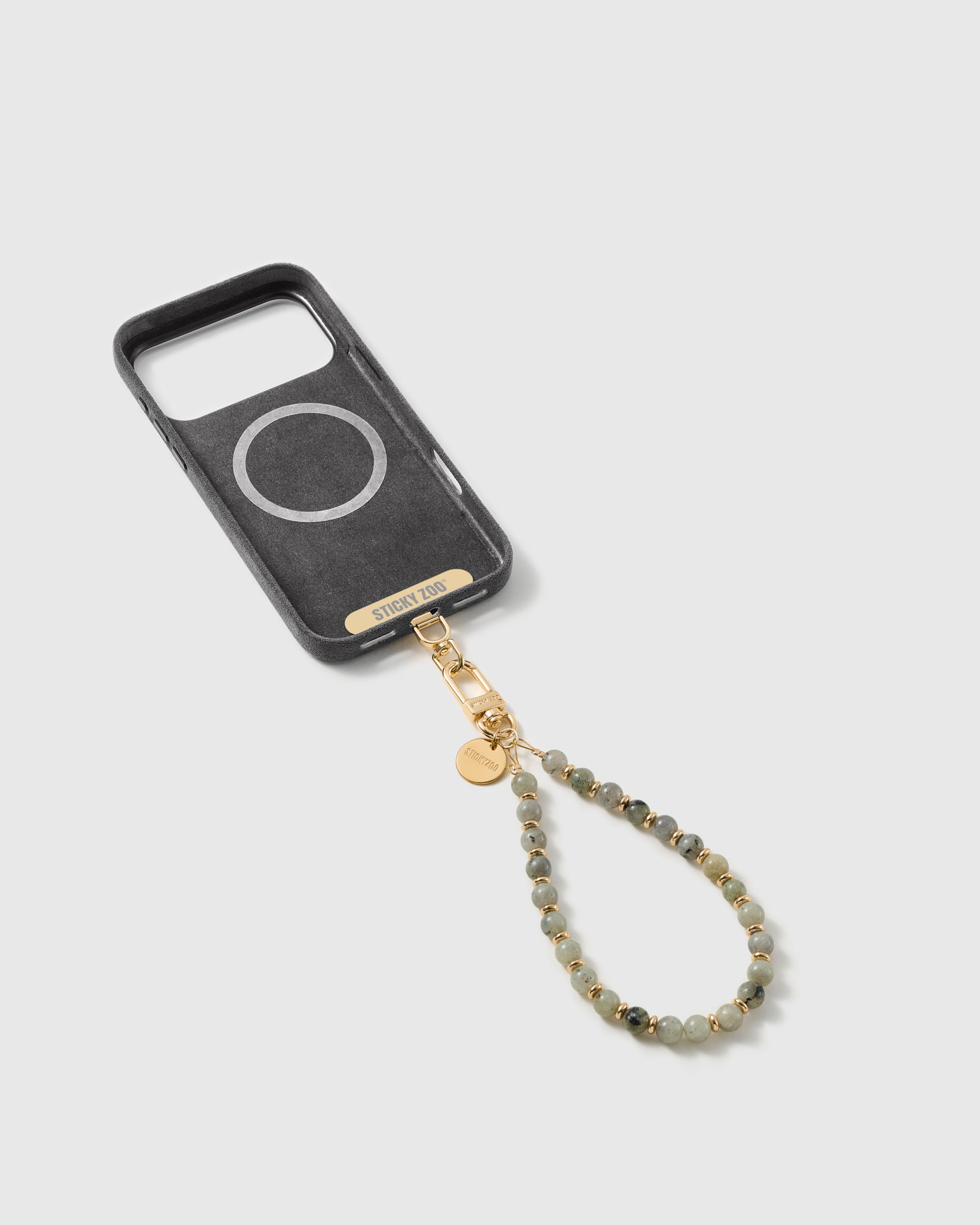 Inside of a phone case showing the included STICKYZOO Phone Strap Card that lets the strap work with any case.