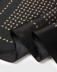 Close-up of the hand-illustrated gold paisley seeds with pale inner dots printed in archival ink on pure silk
